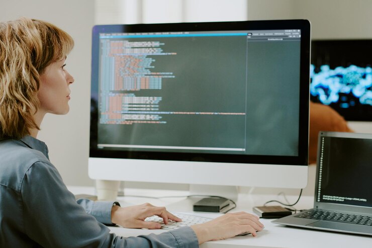 Foto desarrolladora femenina codificando en una computadora de escritorio