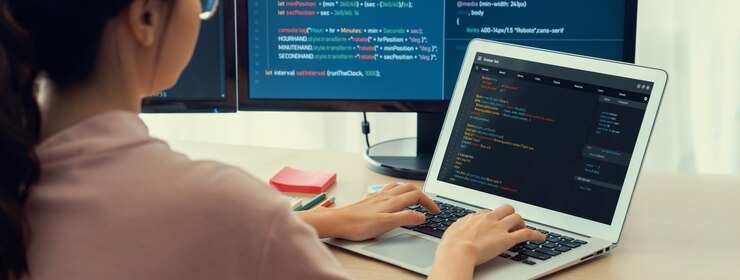 Foto desarrolladora femenina codificando en una computadora portátil mientras la computadora muestra el programa burgeoning