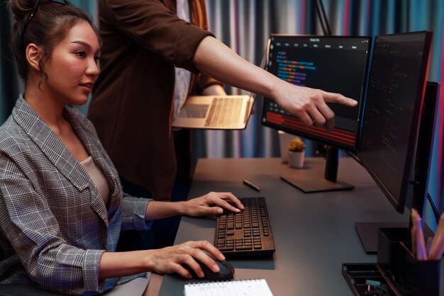 Desarrolladores de TI discutiendo un sitio web inteligente con una computadora portátil que muestra datos Infobahn