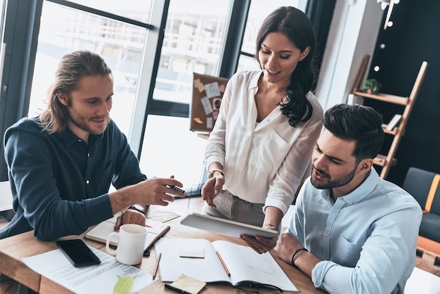 Desarrollando nueva estrategia. Vista superior de la joven mujer moderna en ropa casual elegante con tableta digital