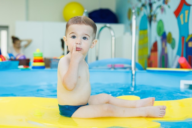 Desarrollo para bebés Un niño pequeño está aprendiendo a nadar en la piscina Primeras lecciones de natación para niños Desarrollo para bebés