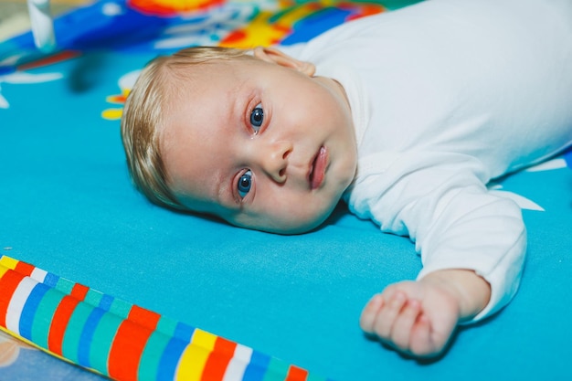 Desarrollo del niño El bebé se acuesta en la alfombra de desarrollo y juega con juguetes Mientras juega, el niño conoce el mundo y aprende formas y colores