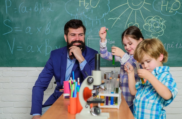 Desarrollo temprano de los niños microscopio instrumento óptico en el aula de ciencias niños felices y maestros de regreso a la escuela aprender a usar el microscopio en la lección de la escuela Donde las pequeñas cosas significan mucho