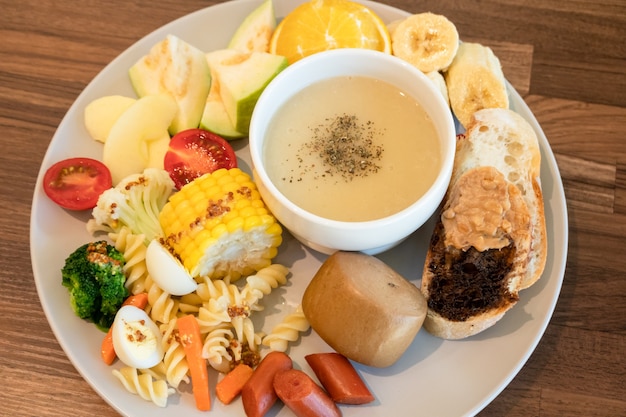 Desayuno abundante con pan y fruta en un plato en casa