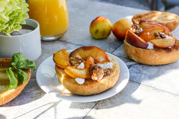 Desayuno al aire libre de panecillos a la plancha con grasa de cabra, fruta, frutos secos, zumo de naranja y café