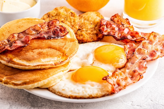 Desayuno americano completo saludable con huevos, tocino, panqueques y latkes