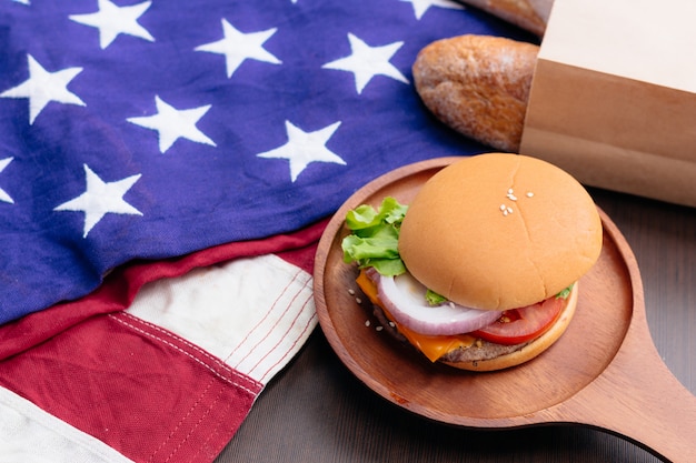 Foto desayuno americano. hamburguesa casera y papas fritas sobre fondo negro.