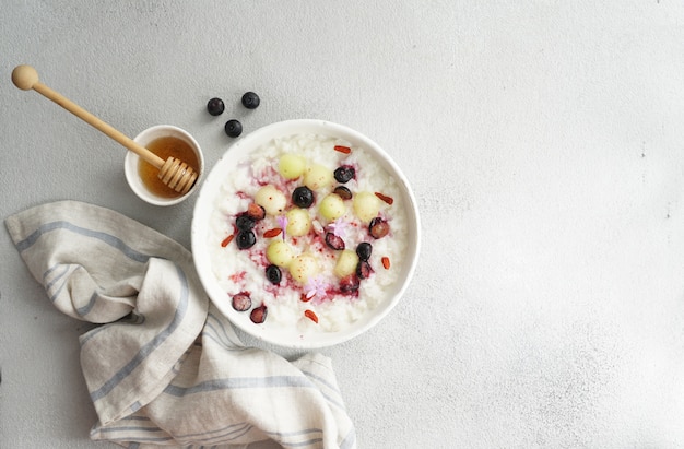 Desayuno arroz porrige con miel y melón, bayas