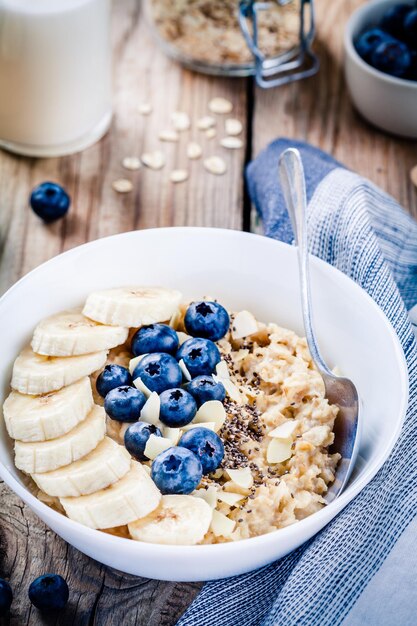 Desayuno avena con plátanos arándanos semillas de chía y almendras Enfoque selectivo