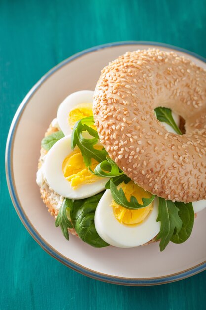 Desayuno Bagel con huevo, queso crema y rúcula