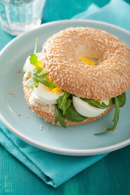 Desayuno Bagel con huevo, queso crema y rúcula