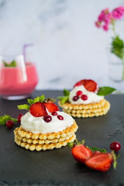 Desayuno con batido orgánico y deliciosos gofres belgas con crema limpiadora y fresas