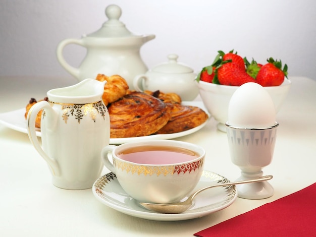 Desayuno con bollos de leche de té de huevo fresa