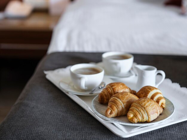 Desayuno con café y croissant en la habitación del hotel.