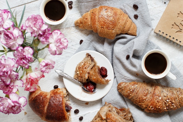 Desayuno con café y croissant con mermelada de fresa de cerca