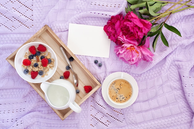 Desayuno con café, granola, moras y leche.