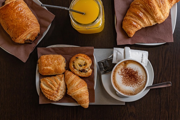 Desayuno con café, jugo de naranja, croissant.