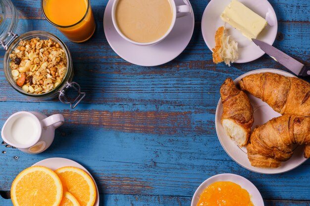 Desayuno con café, zumo, leche, mermelada, naranja.