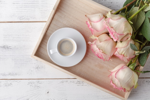 Desayuno en la cama, una bandeja de café, cruasanes, mermelada, flores. Mensaje de amor