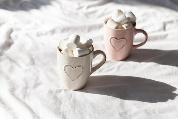 Desayuno en la cama para parejas composición plana pastel con tazas de café y malvavisco dulce. Concepto de mujer o día de San Valentín.