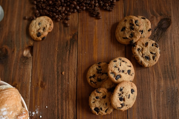 Desayuno capuccino, croissant y deliciosas galletas en una mesa de madera