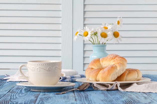 Desayuno en casa de campo con taza de café y croissant.