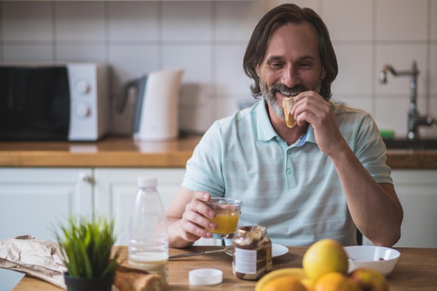 Desayuno en casa. Hombre maduro desayunando y luciendo contento y pacífico