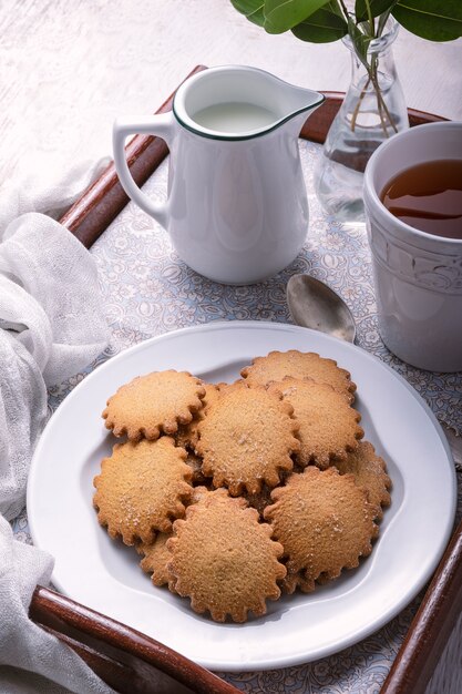 Desayuno casero en una bandeja que consta de galletas de canela y té