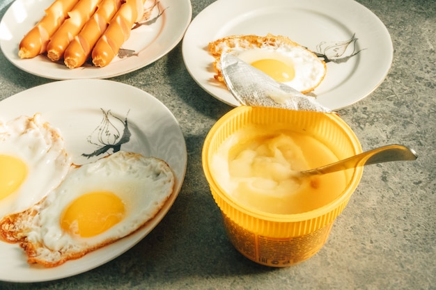 Desayuno casero simple conjunto de huevos fritos y salchichas en la mañana.
