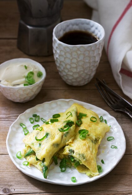 Desayuno casero de tortilla con espárragos y cebolla y café caliente. Estilo rústico