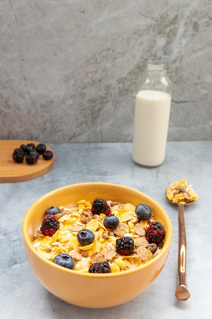 Desayuno con cereales de granola y frutas, como arándanos y moras.