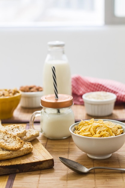 Foto desayuno con cereales de leche y frutos secos en una mesa de madera