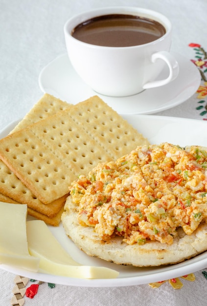 Desayuno colombiano Arepa harina de maíz molida doughegg con salsa tradicional llamada hogado