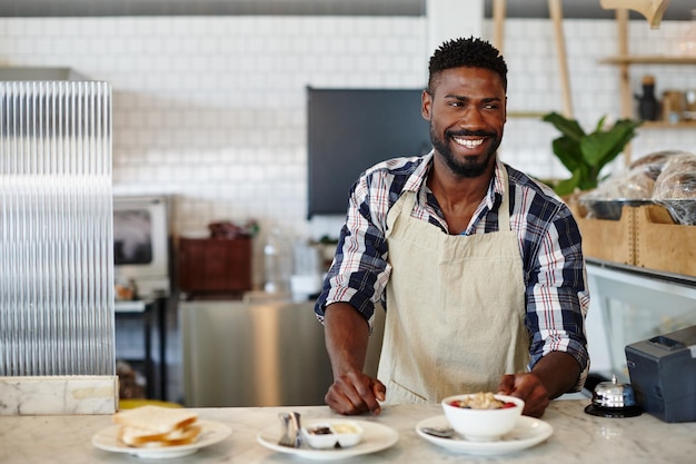 Desayuno, la comida más importante del día Captura recortada de un apuesto joven que trabaja en un café