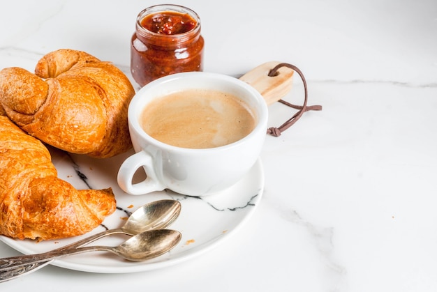 Desayuno continental casero, croissants de café. mermelada en la mesa de mármol blanco, espacio de copia