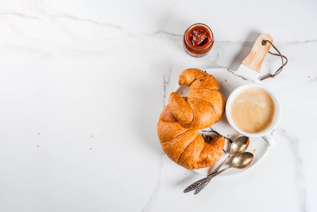 Desayuno continental casero, croissants de café. mermelada en la mesa de mármol blanco, vista superior de copyspace