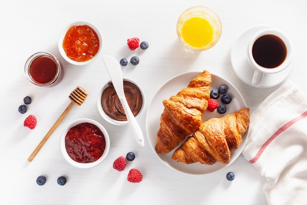 Desayuno continental con croissant, mermelada, chocolate para untar y café. Vista superior