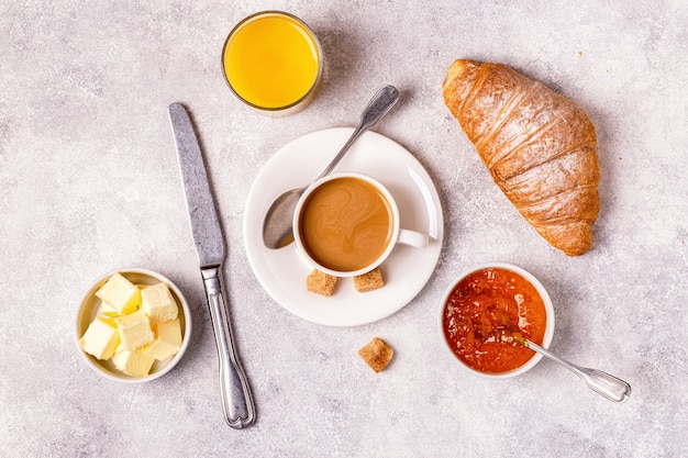 Desayuno continental con croissants recién hechos, jugo de naranja y café.