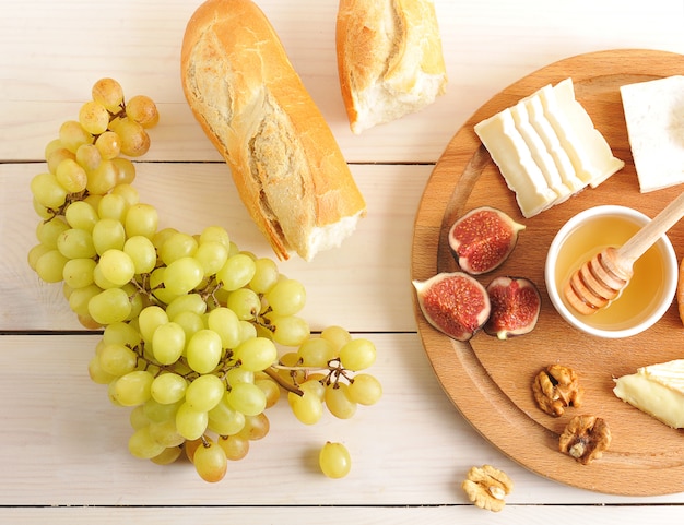 Desayuno continental con queso, miel, higos, nueces, uvas y baguette.