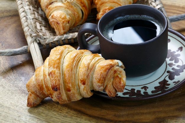 Desayuno con croissant y café negro.