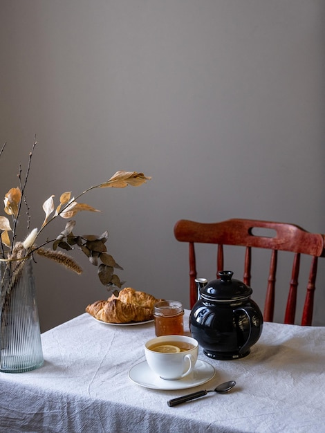 Desayuno de croissant y té negro con limón Desayuno casero para uno