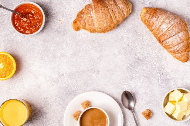 Desayuno con croissants recién hechos, jugo de naranja y café.