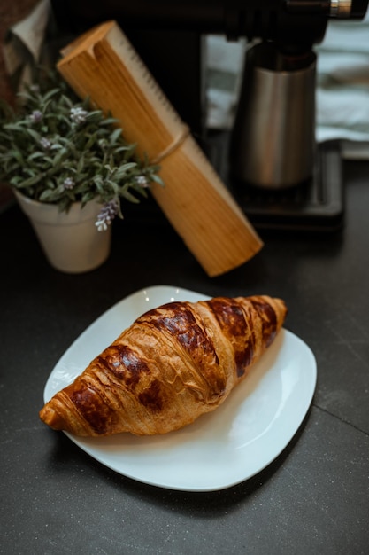 Desayuno con croissants recién hechos en plato blanco