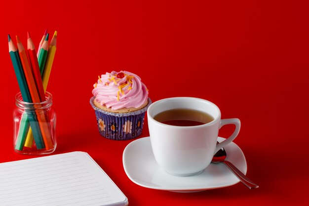 Desayuno con cupcake en espacio rojo brillante
