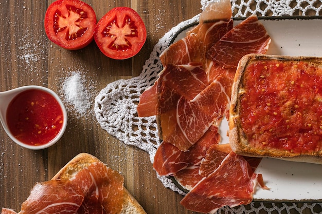 Desayuno de tostada en pan chapata mit Tomate natürlicher Queso Mermelada Jamon Pate und Mermelada