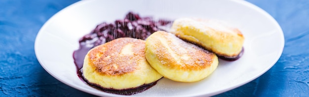 Desayuno y deliciosos panqueques de concepto de requesón con mermelada espolvorear con fondo azul