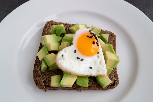 Desayuno en el día de san valentín. Bocadillo con huevo y aguacate.