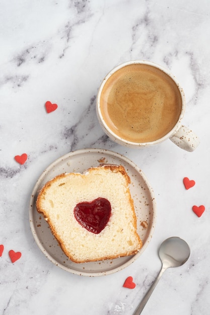 Desayuno del día de san valentín con pastel de corazón y café.