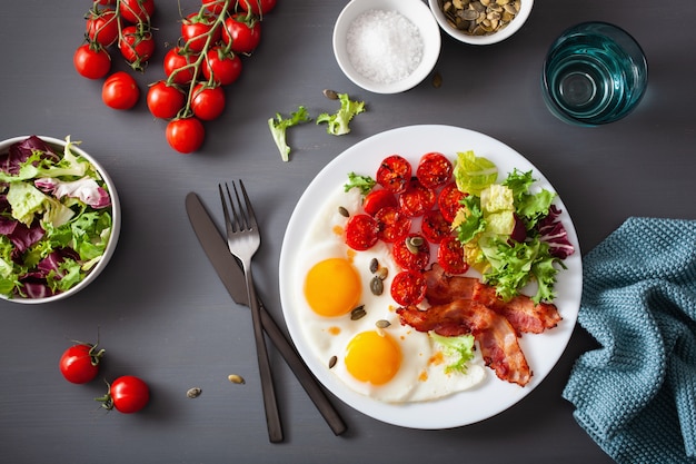 Desayuno de dieta keto saludable: huevo, tomate, hojas de ensalada y tocino