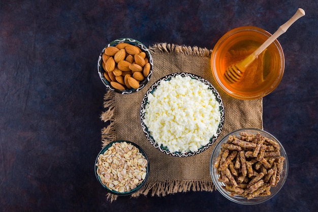 Desayuno de dieta saludable en burlap Ingredientes para un desayuno saludable harina de avena granola miel